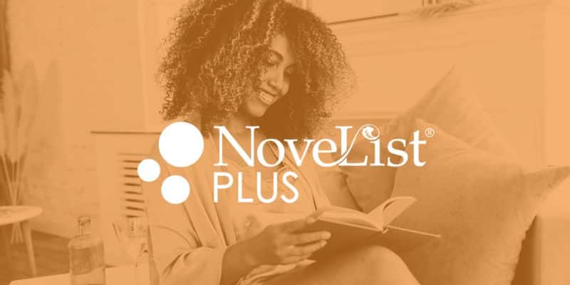 Person smiling while reading book at home