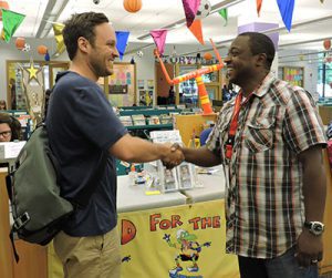 olmes Elementary teacher Drew Finkbeiner and Oak Park Public Library's Rob Simmons shaking hands.