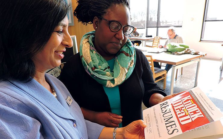 Librarian Rashmi Swain and Trina Wade look at Knock 'Em Dead Resumes