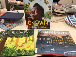 Books displayed on a table: "Crown: Ode to a Fresh Cut," "Little Fox in the Forest," and "Windows."