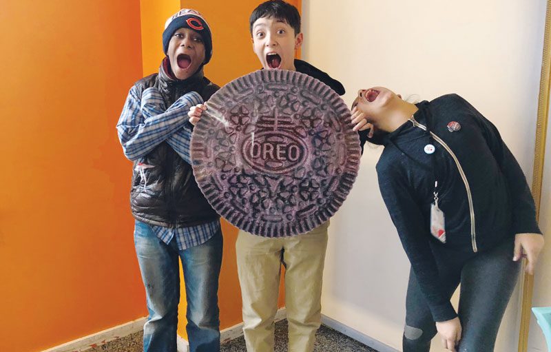 Three kids holding a giant cookie