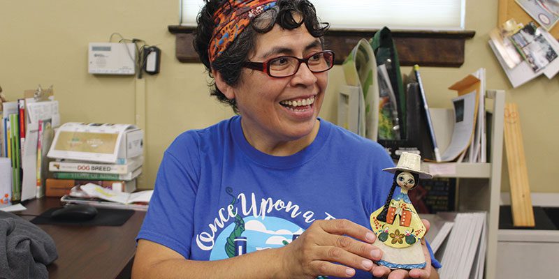 Kathy Valdivia, Multicultural Collection volunteer with artifact