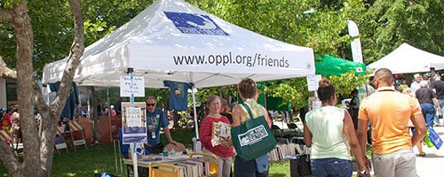 People visiting the Friends of the Library tent