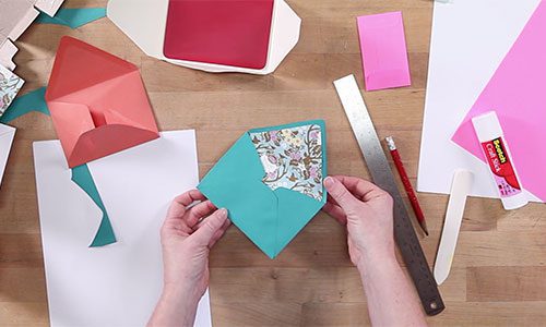 Hands holding a colorful paper envelope