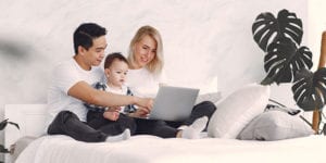 Family with baby looking at laptop