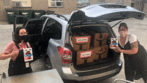 Beronica Puhr and Katy Alejos load van with boxes of books