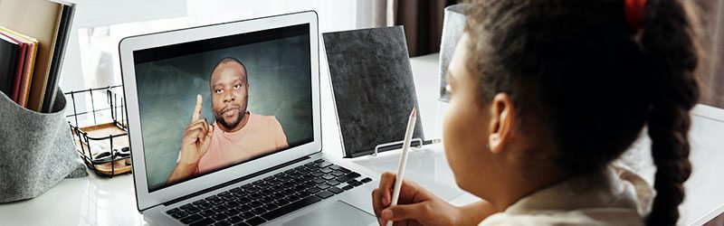 Student watching teacher on laptop