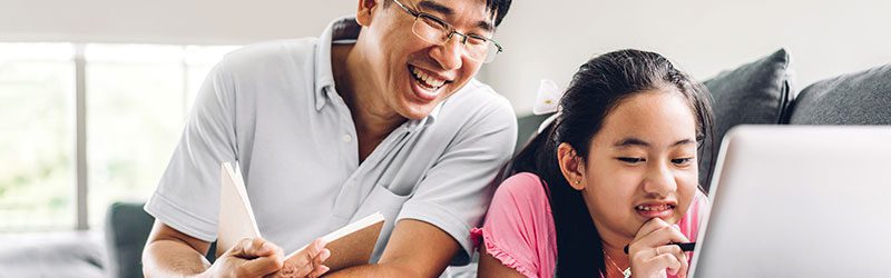 Father and daughter looking at laptop and smiling