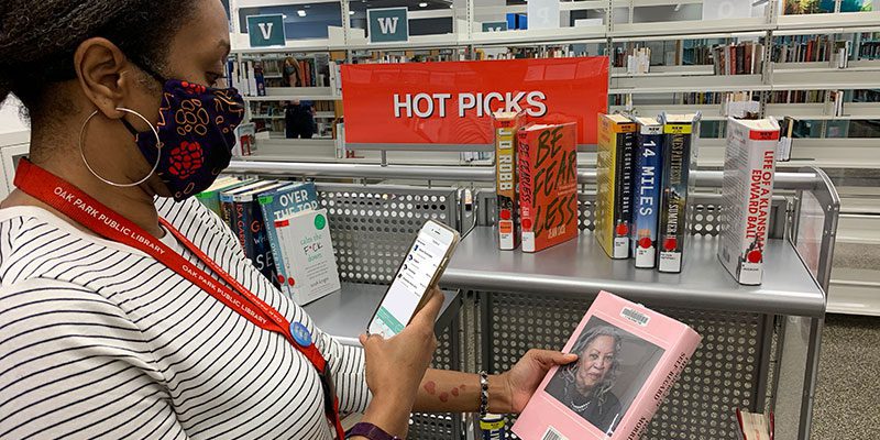 Person checking out book with meeScan app