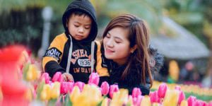Child and grownup examining tulips