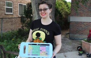 Shelley Harris holds an AAC (Augmentative and Alternative Communication) board in the Maze Branch Community Sensory Garden