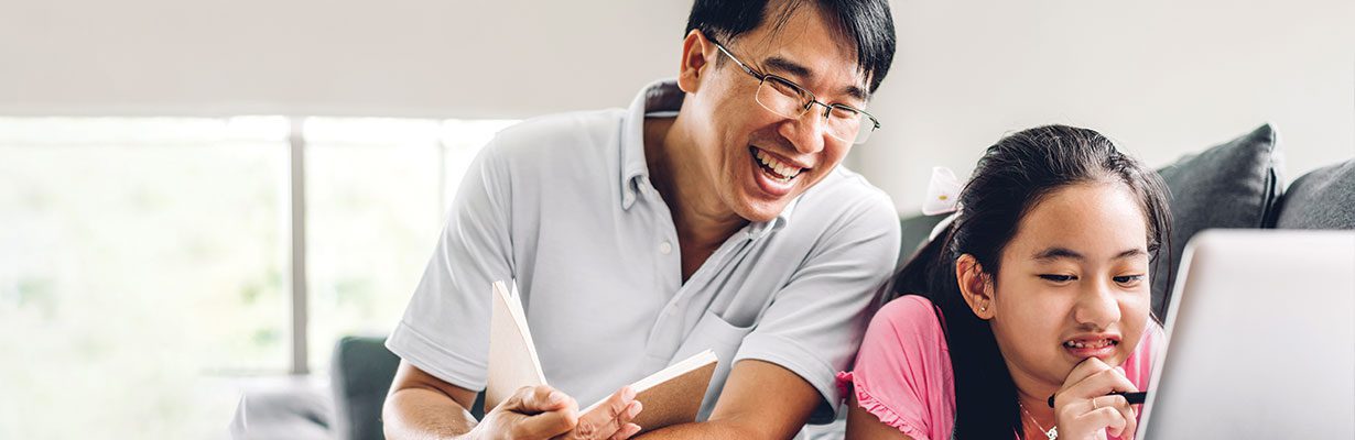 Father and daughter looking at laptop and smiling