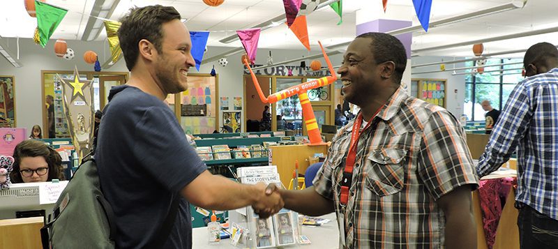 Holmes Elementary teacher Drew Finkbeiner and Oak Park Public Library's Robert Simmons shaking hands.