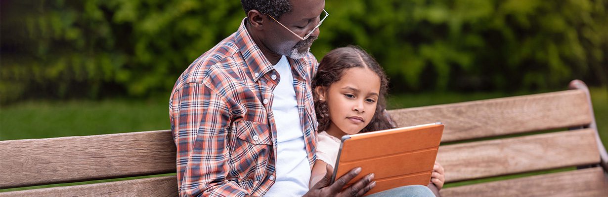 Grandparent and child looking at tablet