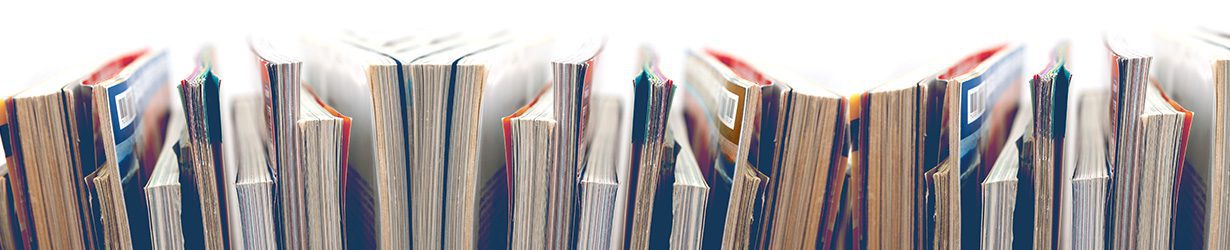 A view of the top of magazines placed on a shelf