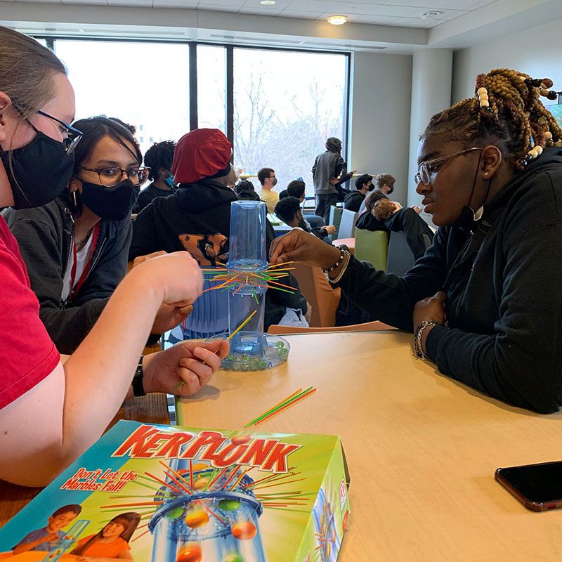 Teens playing Kerplunk with library staff in the Teen Space