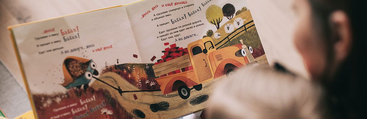 Caregiver and child reading picture book