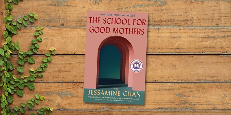 The School For Good Mothers book cover on wooden plank background with growing vine