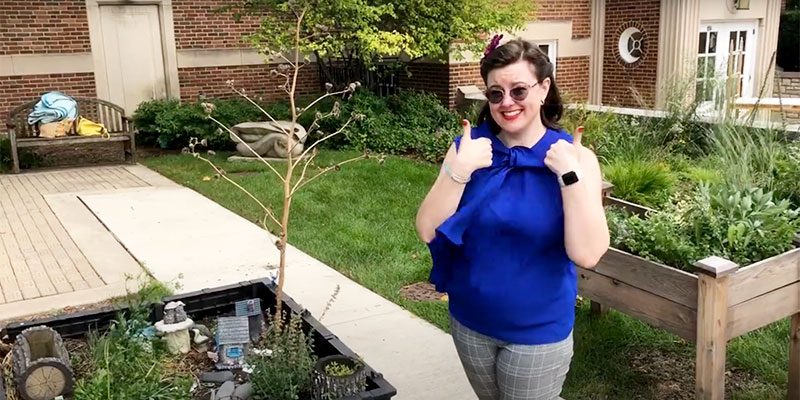 Miss Shelley giving two thumbs up in the Maze Sensory Garden