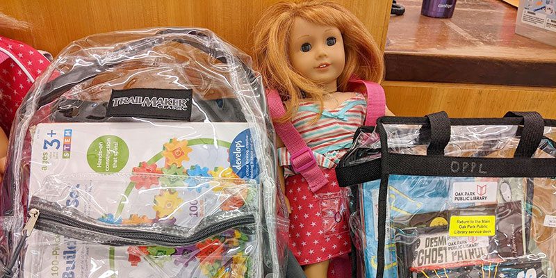 American Girl doll propped up between two Discovery Kits