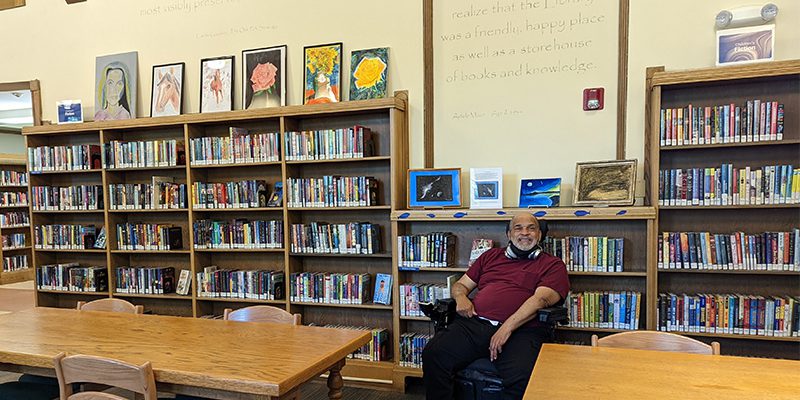 Artist Vanley Roebuck poses with his artwork at Maze Branch