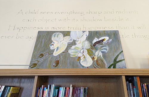 Painting of orchids above bookshelf