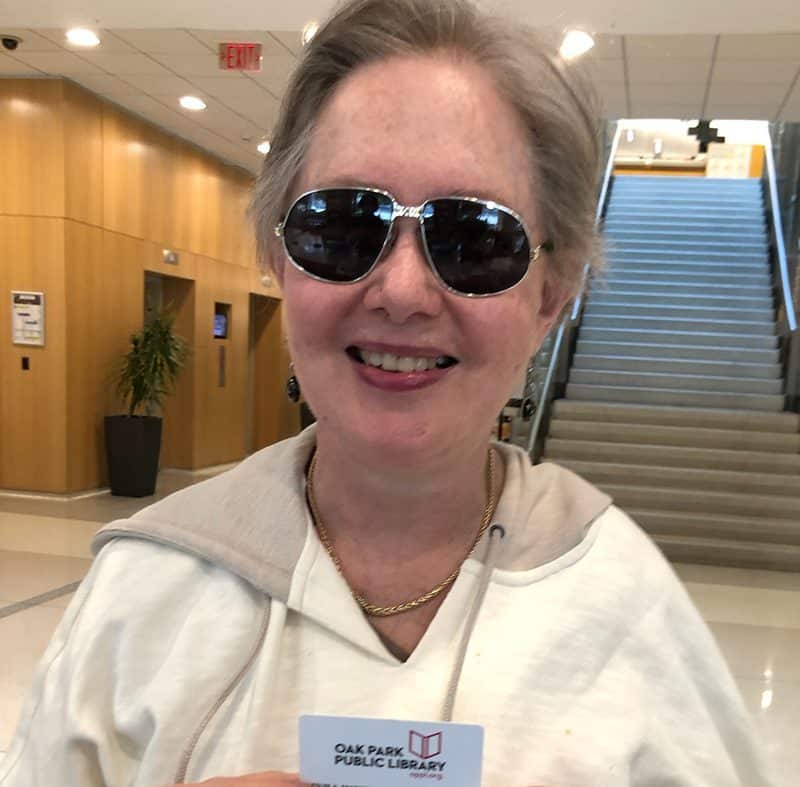 Woman with sunglasses holding library card