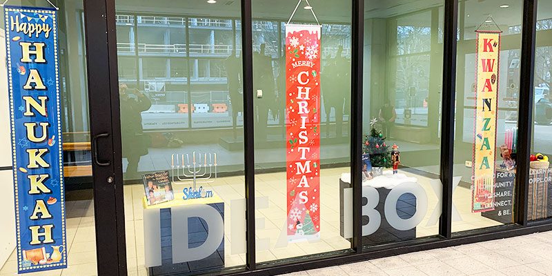 Holidays Around the World display in the Main Library Idea Box with banners for Hanukkah, Christmas, and Kwanzaa