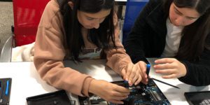 Two middle schoolers disassembling a computer