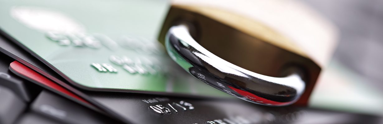 Padlock sitting on top of a pile of credit cards