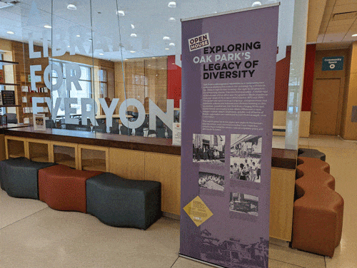 A banner on loan from the Oak Park River Forest Museum in the Main Library lobby, "Exploring Oak Park's Legacy of Diversity"