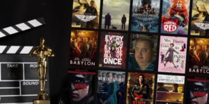 Oscar statue standing in front of a clapperboard, next to a collage of movie covers