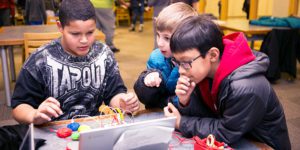 Three students playing a coding game