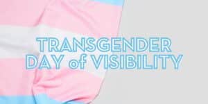 Transgender Day of Visibility text with a blue, pink, and white striped flag in the background