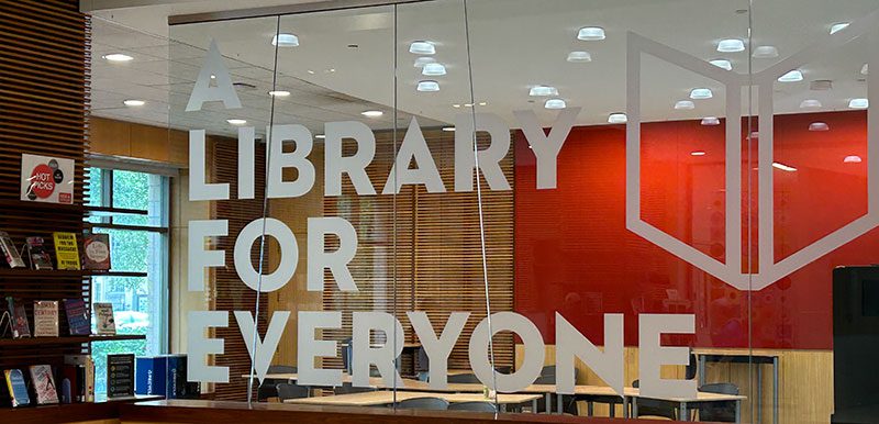 A glass wall with the words "A library for everyone" in frosted letters