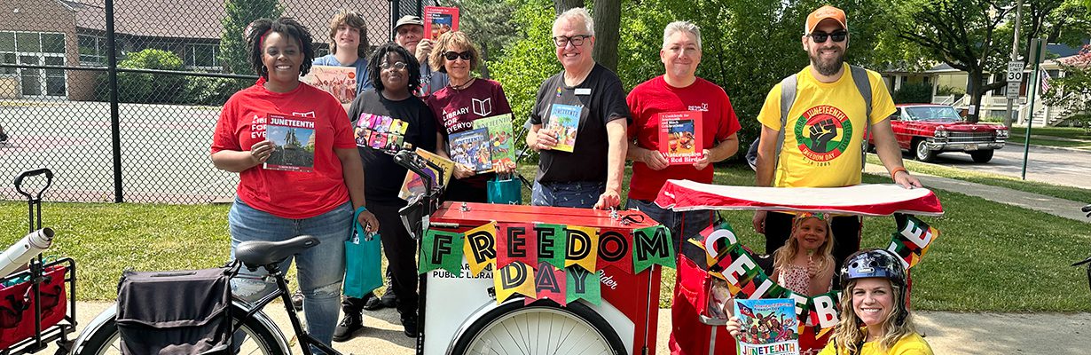 Book Bike decorated for the Juneteenth parade with staff and board members posing