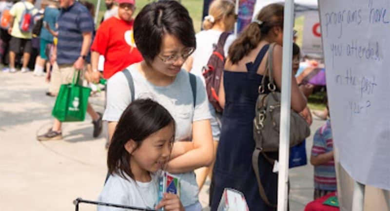 Child and adult at the library's A Day In Our Village booth