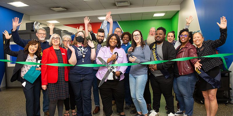 Library staff, board members and Chamber of Commerce members celebrate the opening of the Main Library Creative Studio with a ribbon cutting