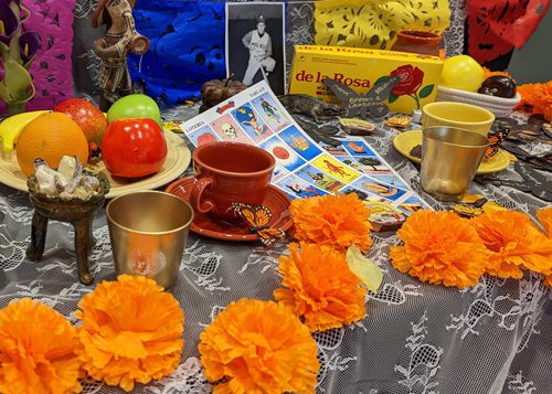 Paper marigolds and other objects on an ofrenda for Dia de Muertos