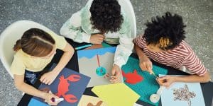 Three kids crafting at a table