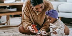 Adult reading a picture book with a baby