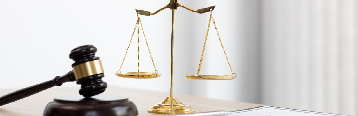 Scales of Justice alongside gavel sitting on a table