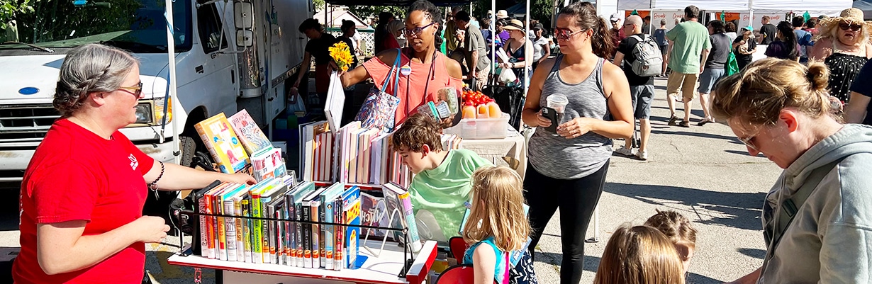 People checking out books from the Book Bike at a community event