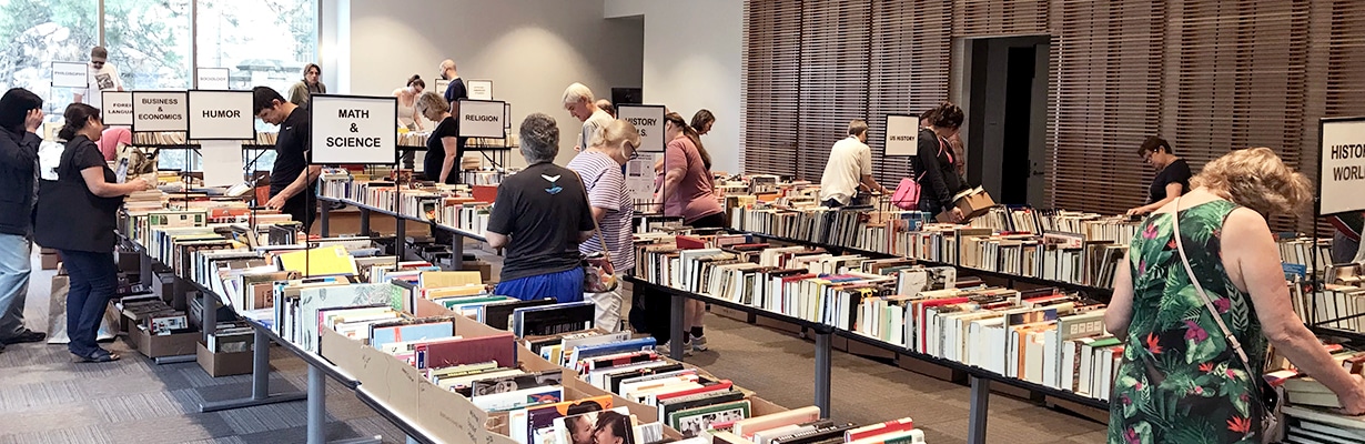 People browsing hundreds of books displayed on long tables