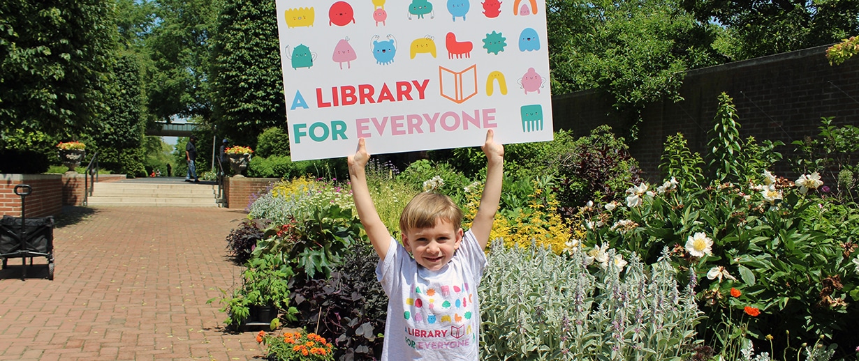 Child holding giant library card
