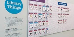 Pegboard wall with hanging tags and text that says "Library of Things"