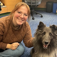 Person smiles next to a dog