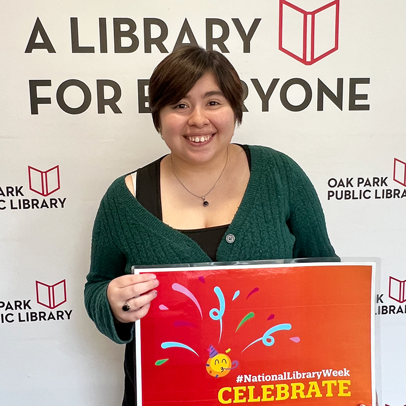 Library staff member holding a sign that reads, #NationalLibraryWeek Celebrate