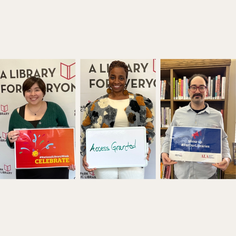 Photo of three staff members holding signs