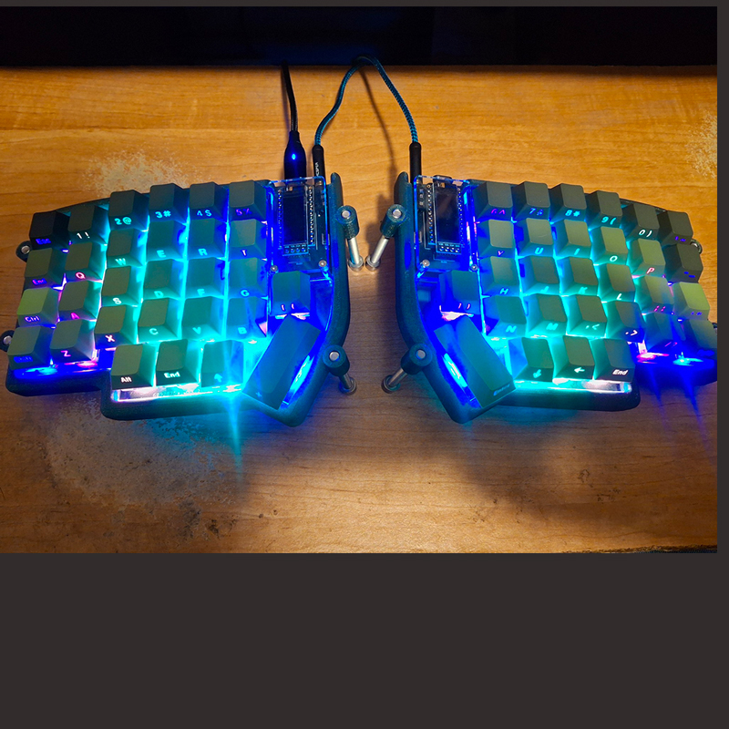 An ergonomic keyboard with the keypad lit up blue and green